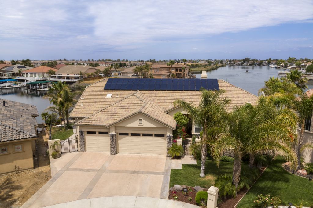 Arial view of a tan residence with solar panels on the roof