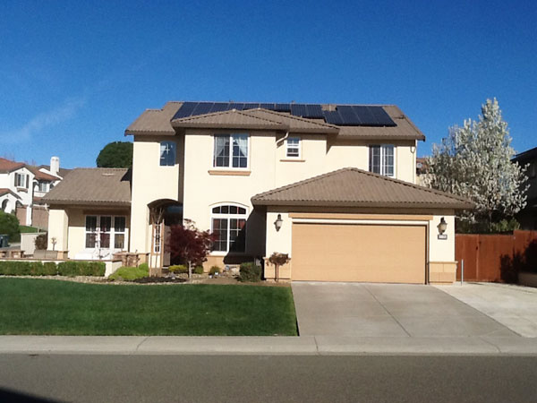 Two story home with a garage and solar panels on the roof